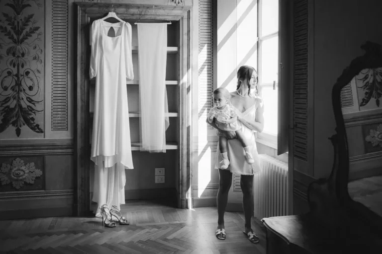 la sposa che tiene in braccio il figlio più piccolo, durante il servizio fotografico di matrimonio in bianco e nero