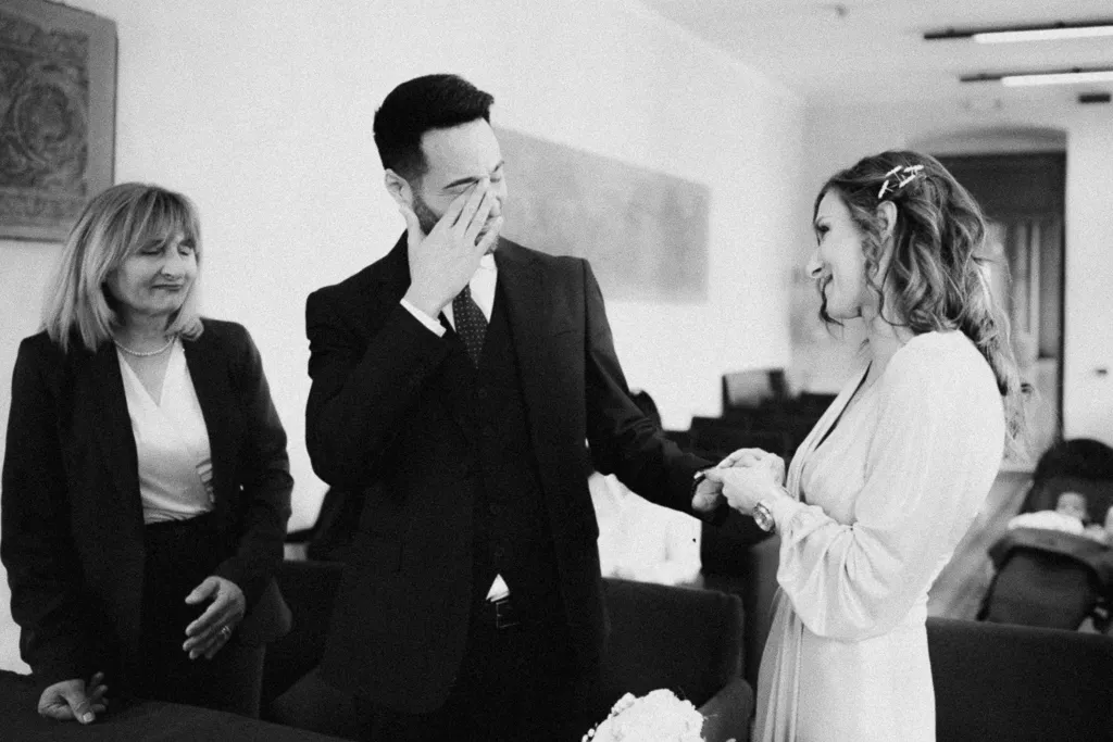 sposo commosso mentre la sposa gli mette l'anello. Come scegliere un fotografo di matrimonio che sappia raccontare davvero il vostro giorno